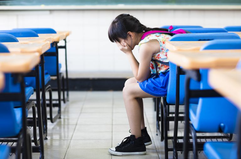 girl experiencing autism behavior problems in classroom
