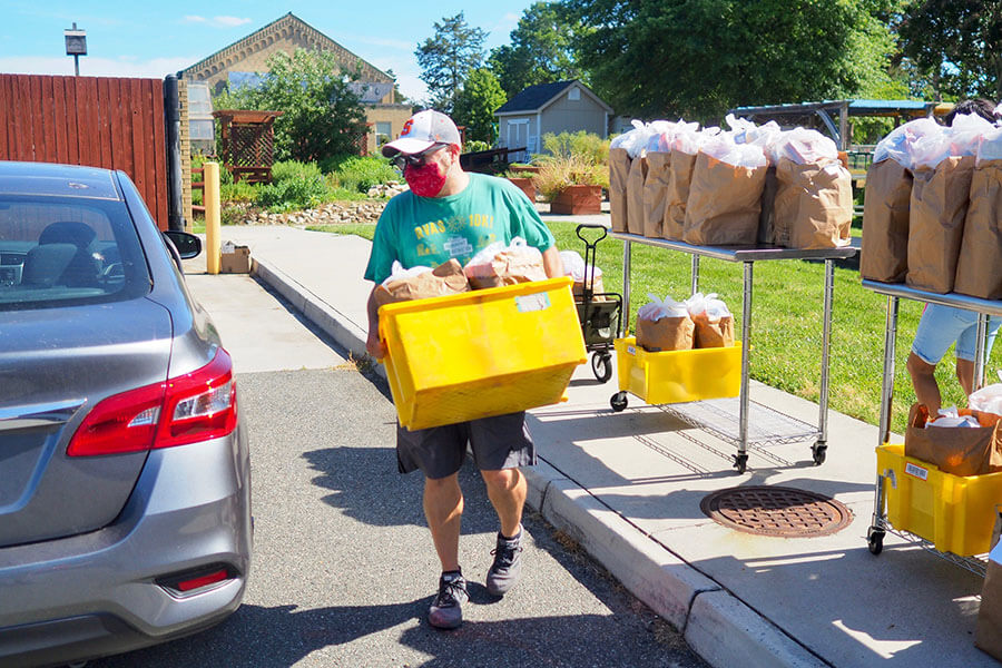 A person carrying a yellow bin